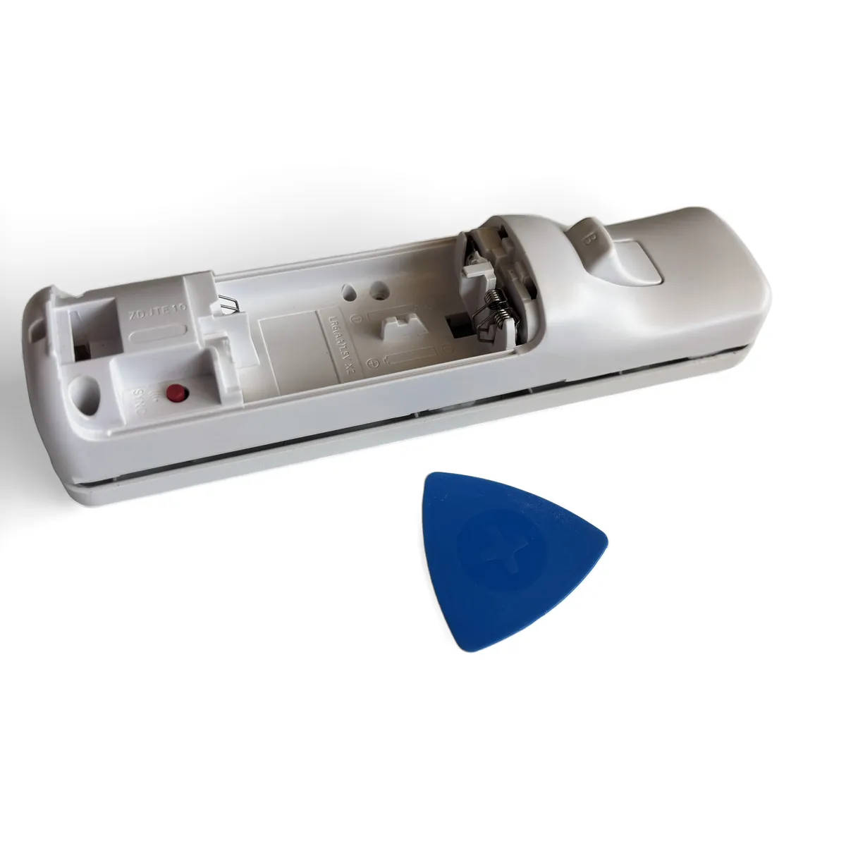 Pick held upright in the seam while the other hand holds the remote